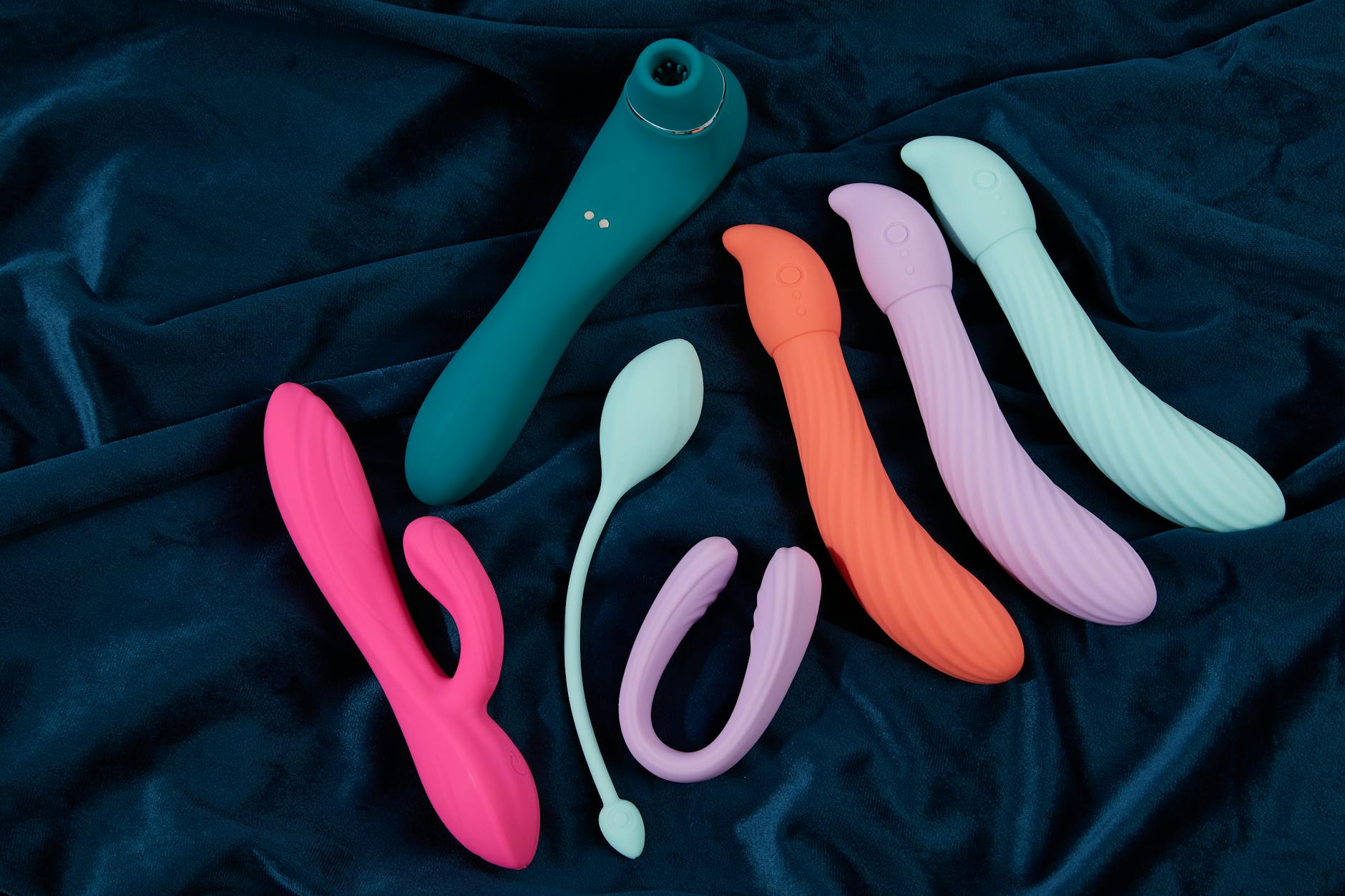 A hand holding a modern vibrator against a minimalist purple background, representing reclaimed autonomy