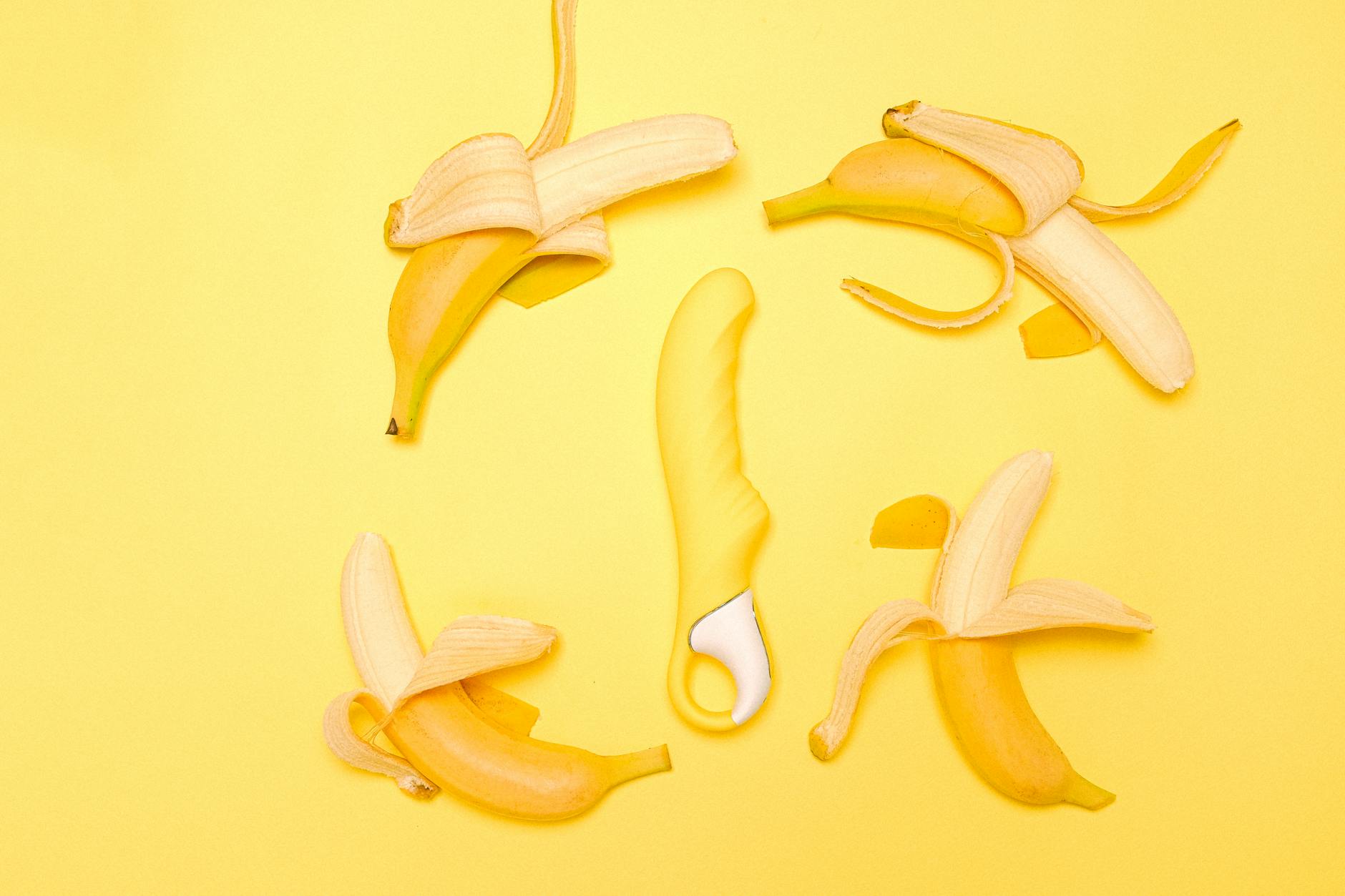 Yellow lemon vibrator surrounded by fresh lemons on a yellow background
